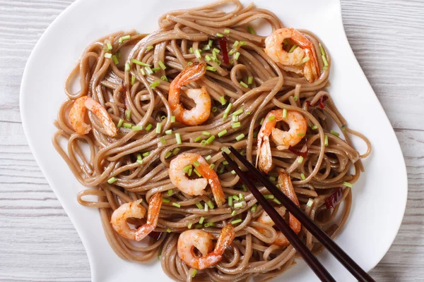 Soba avec crevettes et baguettes gros plan. vue de dessus horizontale — Photo