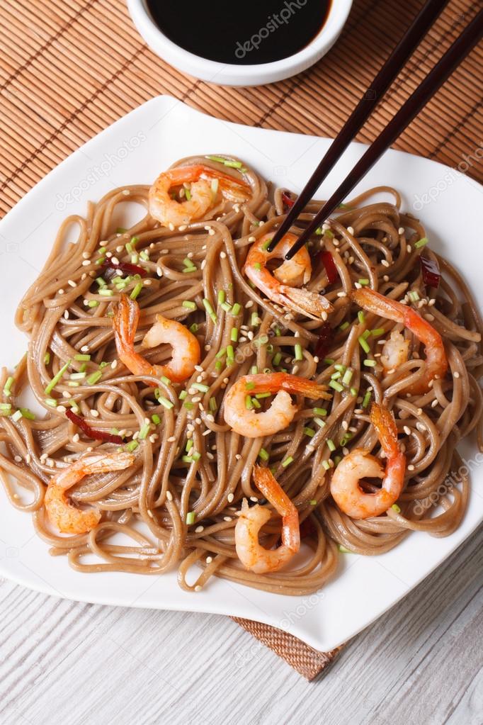 Buckwheat soba noodles with shrimp close-up. vertical top view 