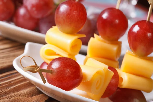 Grapes and cheese on skewers macro on a plate. horizontal — Stock Photo, Image