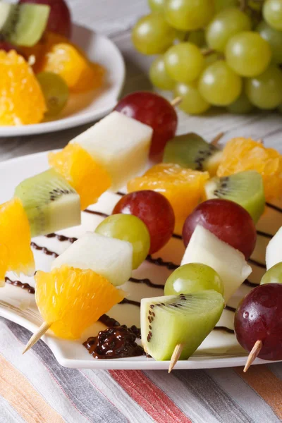 Dessert di frutta fresca sugli spiedini primo piano. Verticale — Foto Stock