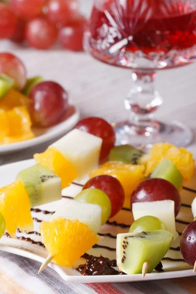 Fresh fruit on skewers and red wine close-up vertical — Stock Photo, Image