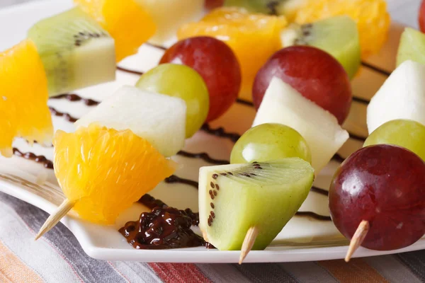 Oranges, kiwis, raisins et poires sur brochettes macro horizontal — Photo