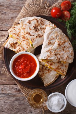 Quesadilla dilimlenmiş ve bir plaka yakın çekim soslar. Dikey üst v