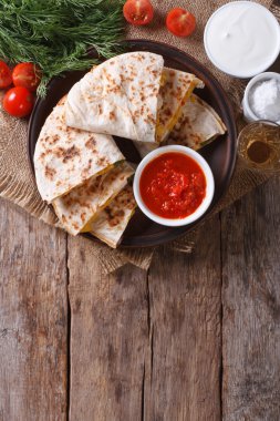 Quesadilla dilimlenmiş ve bir tabağa soslar. Dikey Üstten Görünüm