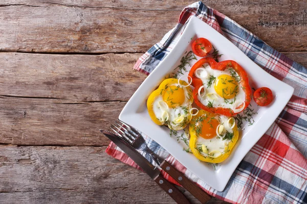 Fried eggs in peppers on a plate. horizontal top view — Stock Photo, Image