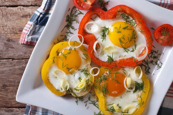 Fried eggs with peppers and tomatoes closeup top view — Stock Photo, Image