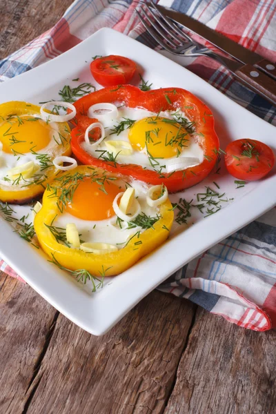 Fried eggs with peppers and tomatoes close-up. Vertical — Stock Photo, Image