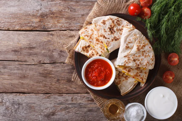 Quesadilla dilimlenmiş ve masaya soslar. horizonta Üstten Görünüm