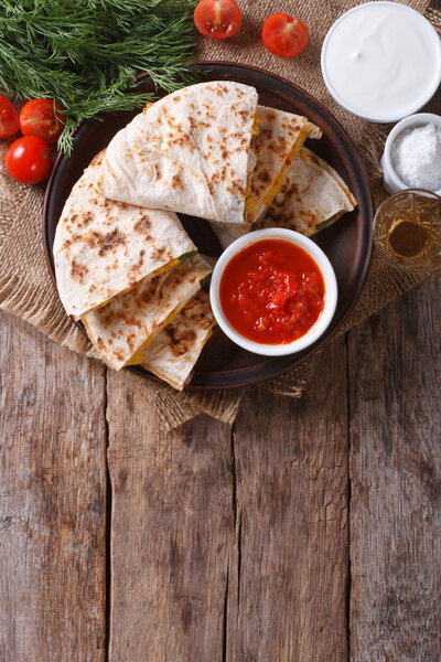 Quesadilla sliced and sauces on a plate. vertical top view