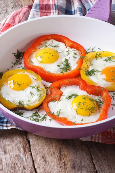 Fried eggs with yellow and red peppers in a pan vertical — Stock Photo, Image