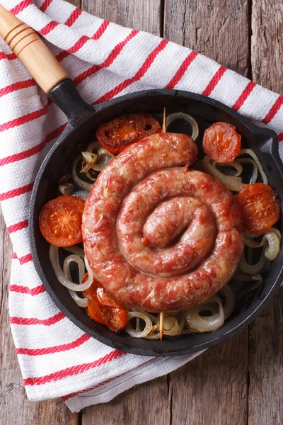Fried sausage with onions in a pan close-up. Vertical top view — Stock Photo, Image