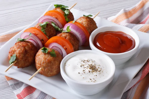 Delicious meatballs on skewers with sauce on a plate horizontal — Stock Photo, Image
