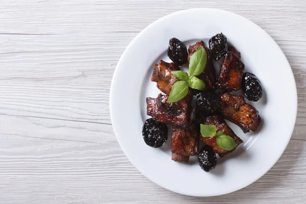 Costillas de cerdo estofadas con ciruelas en un plato. vista superior horizontal —  Fotos de Stock