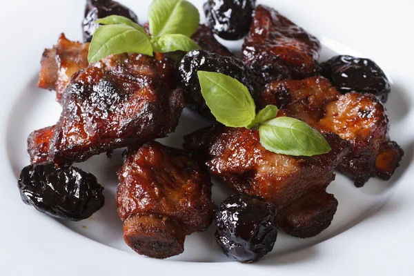 Pork ribs stewed with prunes and basil close-up. — Stock Image Pork ribs stewed with prunes and basil close-up. Stock Photo