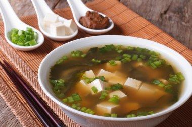 Japanese miso soup in a white bowl and ingredients close-up. Hor clipart