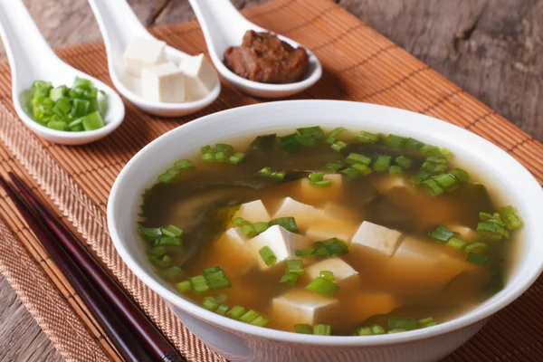 Sopa de miso japonesa en un tazón blanco e ingredientes de cerca. Hor. —  Fotos de Stock