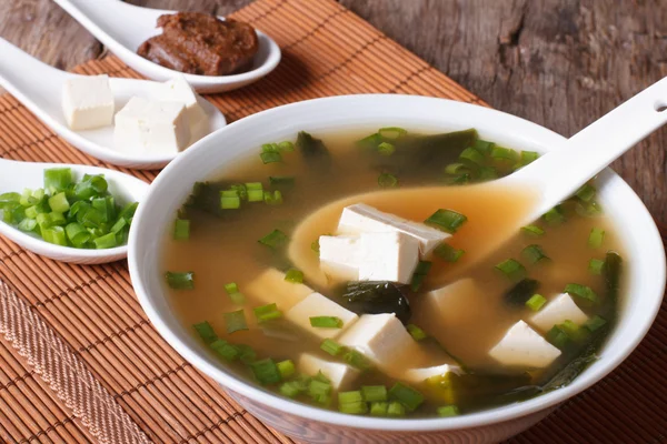 Soupe miso japonaise dans un bol avec une cuillère verticale — Photo