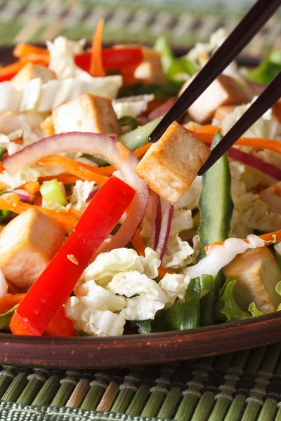 Healthy salad tofu and vegetables with chopsticks macro vertical — Stock Photo, Image