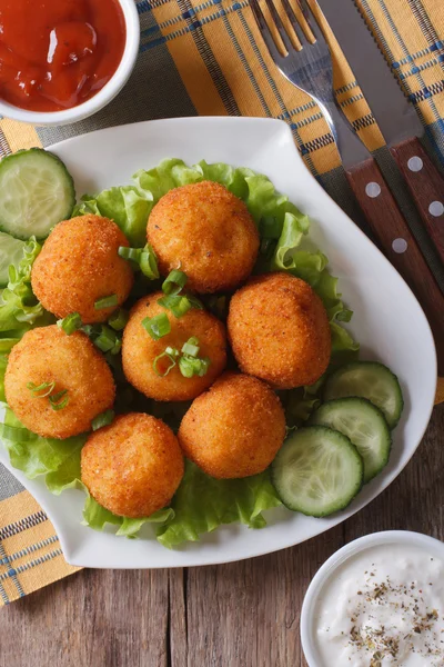 Croquettes de pommes de terre avec laitue et concombre vue de dessus verticale — Photo