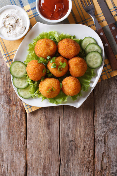 croquette balls with sauce on a plate. vertical top view