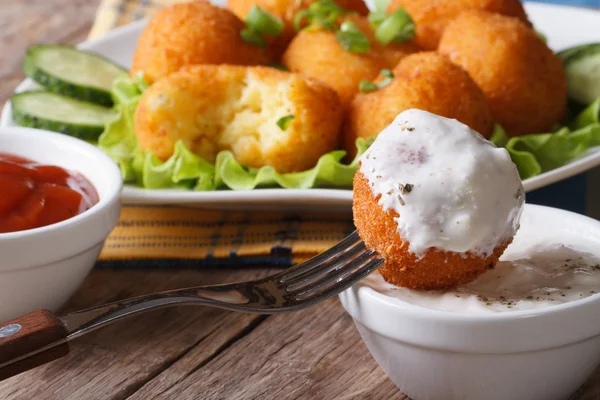 Fried potato balls with sour cream close-up horizontal. — Stock Photo, Image