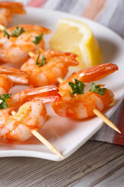 Delicious fried shrimp on wooden skewers macro. Vertical — Stock Photo, Image