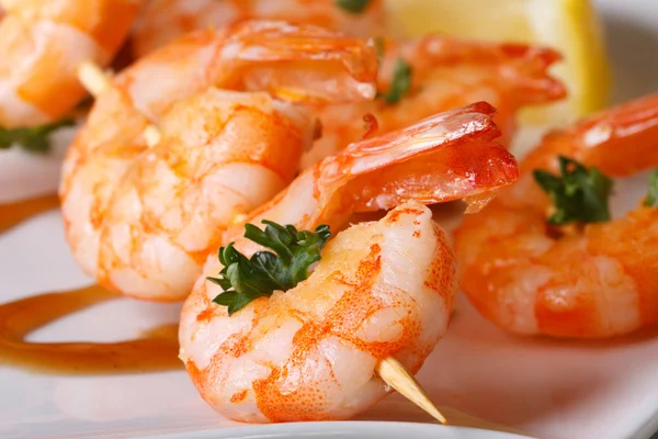 Tasty grilled shrimp on wooden skewers macro with sauce — Stock Photo, Image