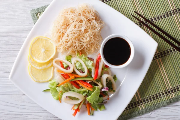 Asian salad with squid and rice noodles horizontal top view — Stock Photo, Image