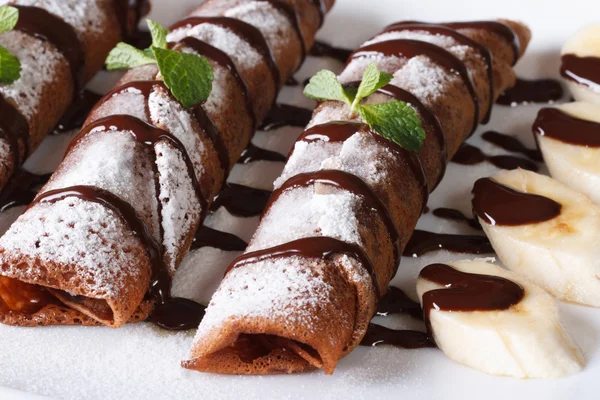 Crepes al cioccolato con salsa e banane primo piano orizzontale — Foto Stock