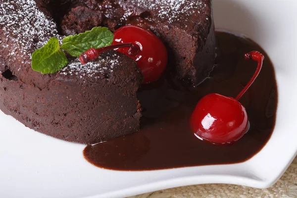 Bolo de chocolate fondant com cerejas e hortelã macro horizontal — Fotografia de Stock