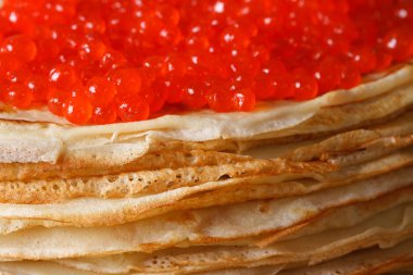A pile of thin crepes with red caviar macro. Horizontal clipart