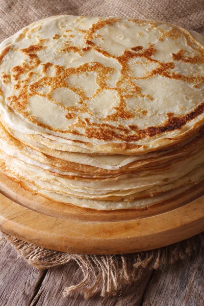 Pilha de crepes em uma placa de cozinha sobre a mesa. Vertical — Fotografia de Stock