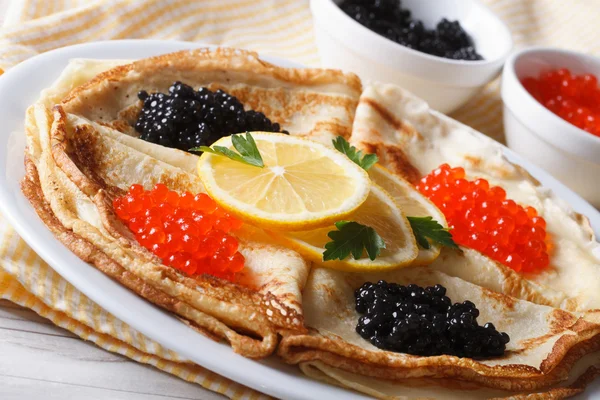 Dünne Pfannkuchen mit rotem und schwarzem Kaviar in Nahaufnahme, waagerecht — Stockfoto