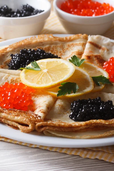 Dünne Pfannkuchen mit rotem und schwarzem Kaviar in Nahaufnahme, vertikal — Stockfoto