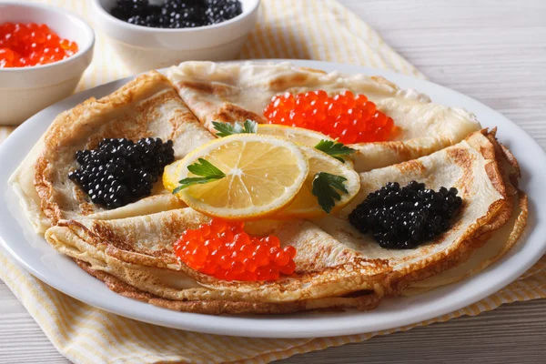 Crepes with red and black caviar close-up, horizontal