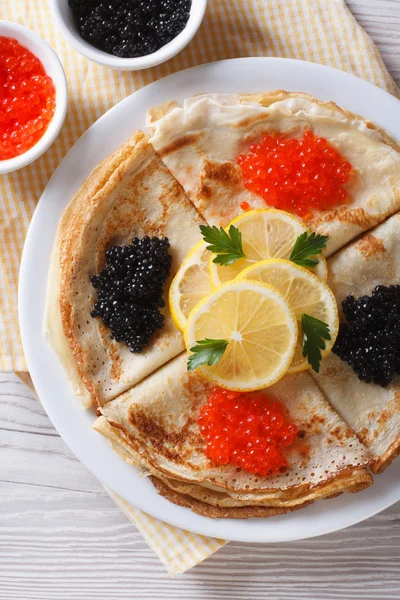 Panqueques con primer plano de caviar rojo y negro, vista superior vertical —  Fotos de Stock