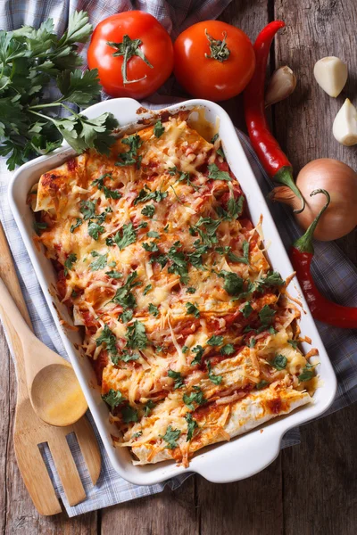 Mexican enchilada in a baking dish vertical top view close-up — Stock Image Mexican enchilada in a baking dish vertical top view close-up Stock Image