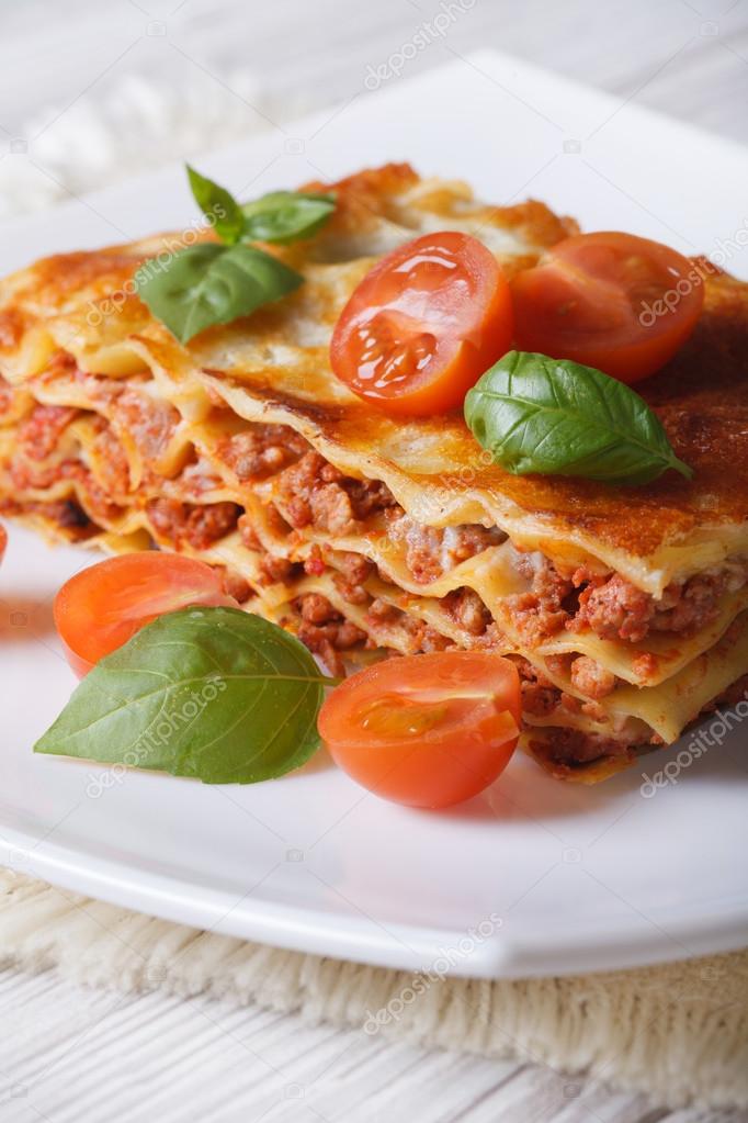 Portion of Italian lasagna on a white plate. Vertical