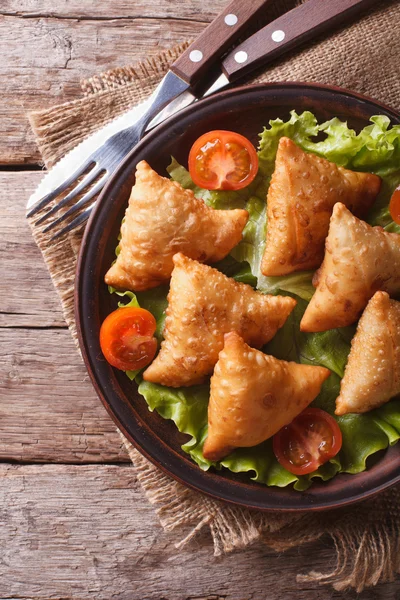 Samosa di pasticceria su un piatto primo piano. Vista verticale dall'alto, rustico — Foto Stock