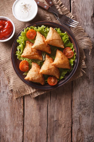 Samosa en un plato con salsa en un plato, vista superior vertical — Foto de Stock