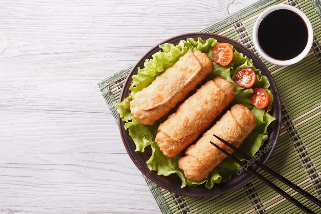 fried spring rolls on a plate with salad, horizontal top view 