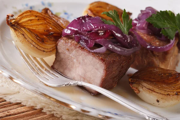 Meat with caramelized onions on a plate closeup. horizontal — Stock Photo, Image