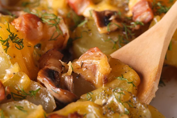 Bratkartoffeln und Fleisch mit einem Holzlöffel Makrovertikal — Stockfoto