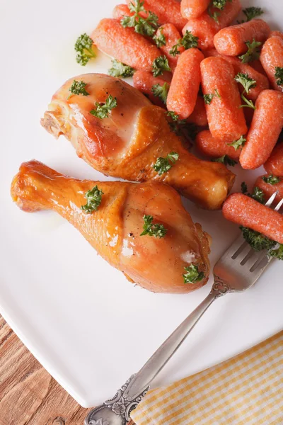 Roasted chicken legs and caramelized carrots vertical top view — Stock Photo, Image