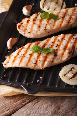 Chicken fillet with onion and basil in a pan grill vertical clipart