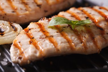 Soğan ve fesleğen ızgara makro üzerinde tavuk göğsü