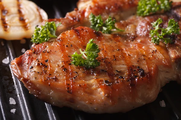 Juicy pork steak grilled with onions in a pan grill macro — Stock Photo, Image