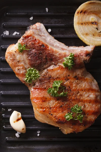 Жареный свиной стейк с луком в кастрюле-гриле. вертикальный вид сверху — стоковое фото