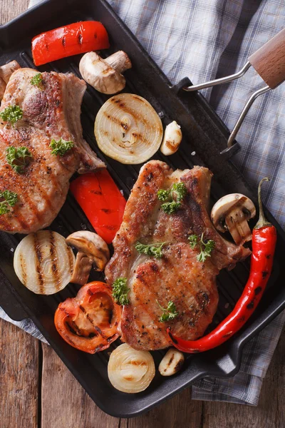 A húst egy serpenyőben grill gombával. Vértes függőleges felülnézet — Stock Fotó