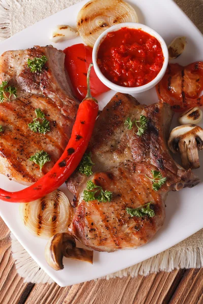 Steak de porc avec légumes grillés sur assiette, vue verticale sur le dessus — Photo